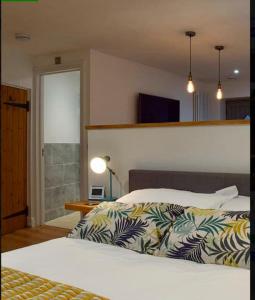 um quarto com uma cama com uma colcha em The Snug Entire home Sleeps 2, Stratford upon Avon em Shottery