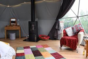 a room with a tent with a fireplace and a chair at Norwegian Wood in Rhayader