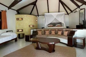 sala de estar con sofá y mesa en Ravintsara Wellness Hotel, en Ambaro