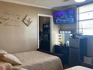 1 dormitorio con 1 cama y TV en la pared en Ocean View Renovated Condo With Pool - DAYTONA BEACH, en Daytona Beach