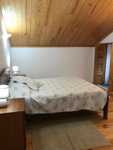 1 dormitorio con cama y techo de madera en Casas da Nascente en Loriga