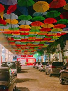 a bunch of umbrellas hanging from a ceiling in a parking lot at NGỌC HƯNG HOTEL in Vĩnh Long