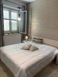 ein großes weißes Bett in einem Schlafzimmer mit Fenster in der Unterkunft Villa Maria in Aragona