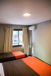 a small room with two beds and a window at Lomas Apart Hotel in Mendoza