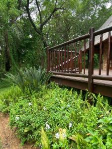 een houten brug over een tuin met planten bij Kruger Park Lodge, Kubu Lodge 224 in Hazyview