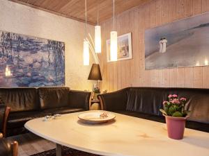 Rødhusにある12 person holiday home in Pandrupのリビングルーム(テーブル、革張りのソファ付)