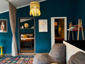 ein Wohnzimmer mit blauen Wänden und einem Kronleuchter in der Unterkunft Light and Bright Central in Pristina