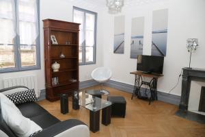 a living room with a couch and a tv at Appartement Bourgeois in Honfleur