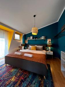 1 dormitorio con 1 cama grande y paredes azules en Light and Bright Central, en Pristina