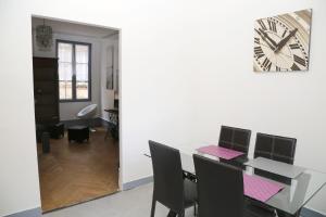 a dining room with a table and a clock on the wall at Appartement Bourgeois in Honfleur