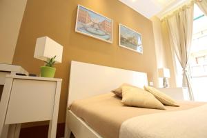 ローマにあるジュリエッタ アル コロッセオB＆Bのベッドルーム1室(白いヘッドボード付きのベッド1台、窓付)