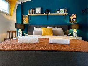 a bedroom with a large bed with a blue wall at Light and Bright Central in Prishtinë