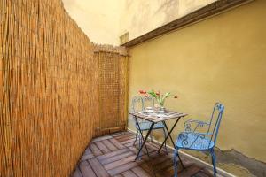 a table with two chairs and a table with flowers on it at La Sinagoga Suite-Hosted by Sweetstay in Florence