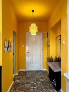 um corredor com uma porta branca e paredes amarelas em Light and Bright Central em Pristina