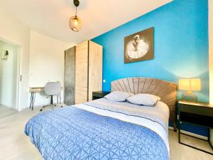 um quarto azul com uma cama e uma parede azul em COLMAR - Appartements Deluxe - Lumineux - Stationnement Gratuit et Facile dans la rue em Colmar