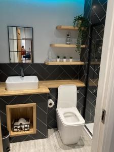 a bathroom with a white toilet and a sink at Vibe Holiday Apartments in Blackpool