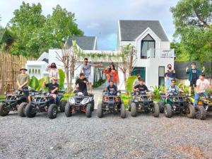 a group of people riding atvs in front of a house at Kampot River Bungalow by MAMA in Kampot