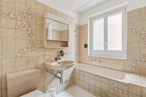 ein Badezimmer mit einem Waschbecken, einer Badewanne und einem WC in der Unterkunft Central Apartment for City Explorers 224 in Zürich