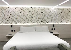 A bed or beds in a room at The Andy Hotel