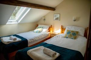 two twin beds in a room with a window at Pentre Fach in Llanddewi Ystradenny