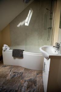 y baño con bañera y lavamanos. en Pentre Fawr en Llanddewi Ystradenny