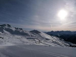 una montaña cubierta de nieve con el sol en el cielo en Apartment Filzenkogel, en Schwendau