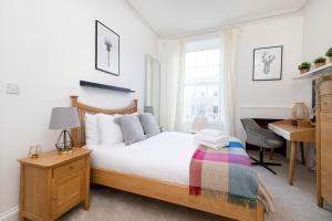 ALTIDO Bright 2 bed flat, sleeps 6, next to Holyrood Park في إدنبرة: غرفة نوم مع سرير ومكتب ومكتب