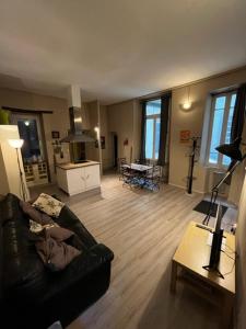 sala de estar con sofá negro y suelo de madera en COSY House T3 City Center, Museum, Place Carnot, en Carcassonne
