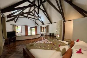 a large room with two beds with flowers on the floor at Ravintsara Wellness Hotel in Ambaro