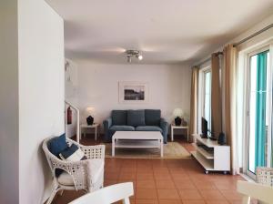 a living room with a blue couch and chairs at Townhouse Prainha Beach in Alvor