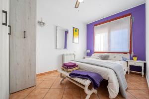 a bedroom with a large bed with purple walls at Abeles' home Villa de Alquiler in Masllorens