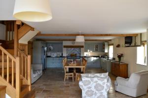 a kitchen and living room with a table and chairs at The Hayloft in Knighton