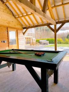 a ping pong table in a house with a pool at The Hayloft in Knighton