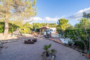 a backyard with a playground and a house at Abeles' home Villa de Alquiler in Masllorens
