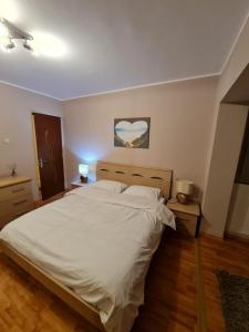 a bedroom with a white bed and two night stands at Apartament Avram in Petroşani