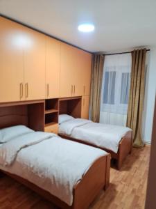 a room with three beds and a large window at Apartament Avram in Petroşani