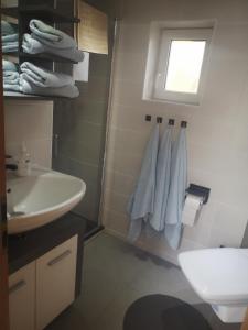 La salle de bains est pourvue d'un lavabo, de toilettes et de serviettes. dans l'établissement S&H Ferienwohnung, à Usedom Town