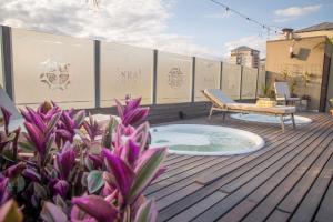 a patio with a hot tub and a bench on a deck at Hotel Inkai in Salta