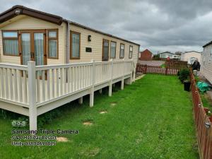 a tiny house in a yard with a fence at 149 Holiday Resort Unity 3 bedroom passes included in Brean