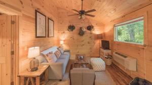 a living room with a blue couch in a log cabin at Affordable cabin that sleeps 8 K beds & fire pit in Cosby