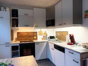 une cuisine avec des armoires blanches et un comptoir dans l'établissement Ferienwohnung Bullentäle, à Albstadt