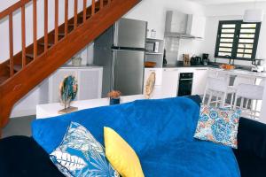 - un canapé bleu dans un salon avec une cuisine dans l'établissement Villa neuve avec piscine privée, à Saint-Pierre