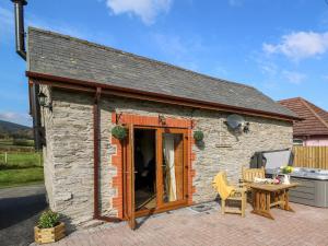 a small stone house with a table at Tegfan Barn in Pant-y-dwr