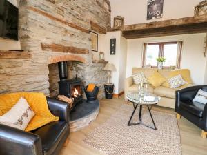 a living room with a stone wall and a fireplace at Tegfan Barn in Pant-y-dwr