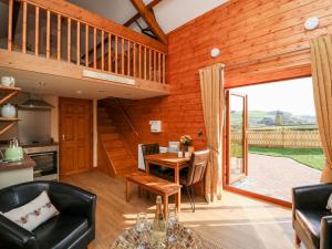 a living room with a table and chairs and a kitchen at Tegfan Barn in Pant-y-dwr