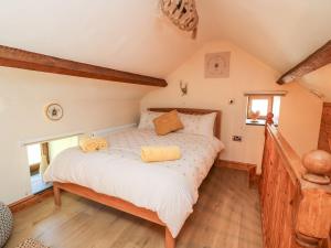 a bedroom with a bed with two pillows on it at Tegfan Barn in Pant-y-dwr