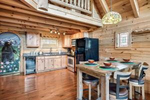 een keuken met houten wanden en een tafel met stoelen bij Alpine Rose Beautiful Cabin Hot Tub Mountain Views in Sevierville