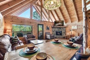 uma sala de estar com uma mesa e uma lareira em Alpine Rose Beautiful Cabin Hot Tub Mountain Views em Sevierville