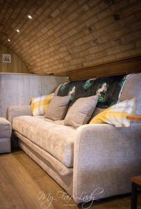 a couch with pillows on it in a room at The Prancing Pony in Llanrhaeadr-ym-Mochnant