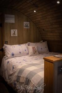 a bedroom with a bed in a wooden room at The Prancing Pony in Llanrhaeadr-ym-Mochnant
